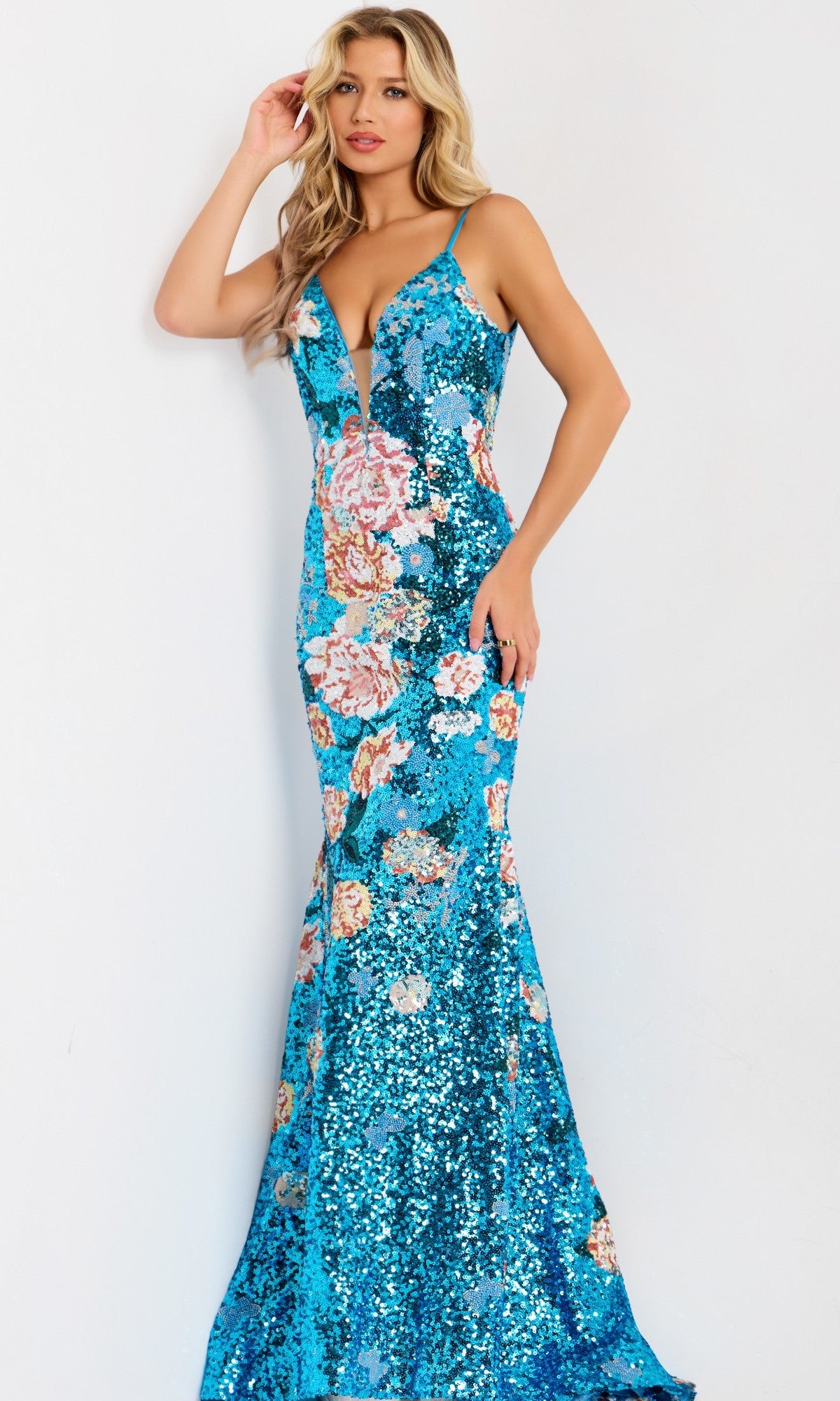 A woman stands against a plain white background wearing the Jovani 48637 long prom dress, a sleeveless, floor-length gown with floral sequins, a mermaid silhouette, and a deep V neckline.